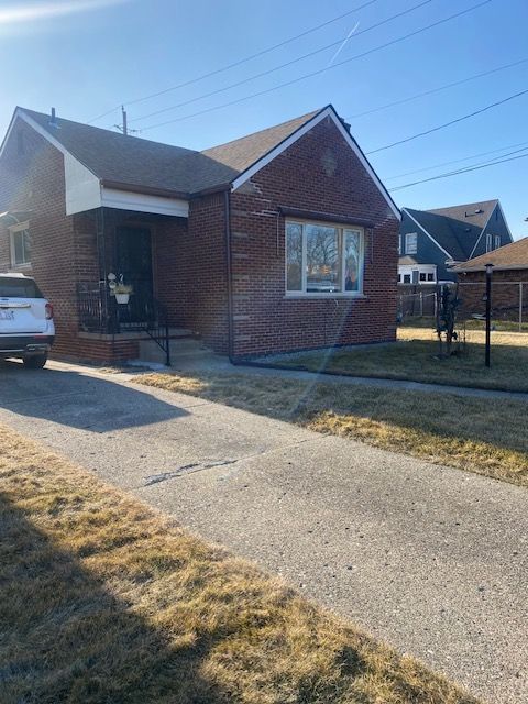 exterior space with brick siding, a porch, and a front lawn