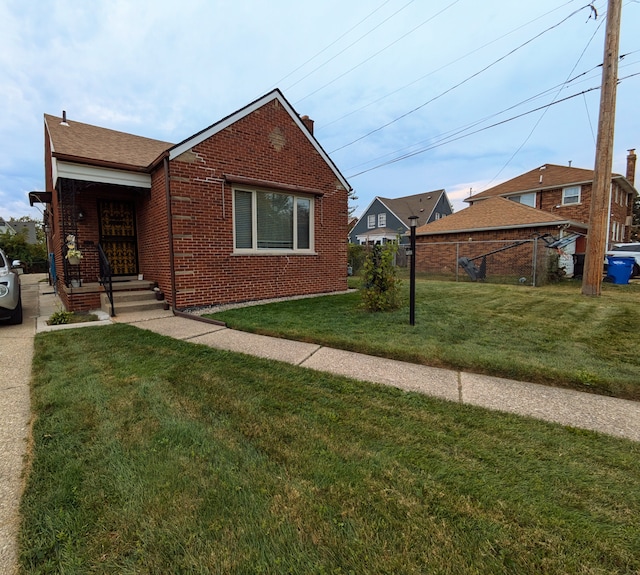 view of front of property with a front yard, fence, brick siding, and a chimney