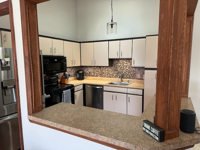 kitchen featuring a sink, decorative backsplash, black appliances, and white cabinetry