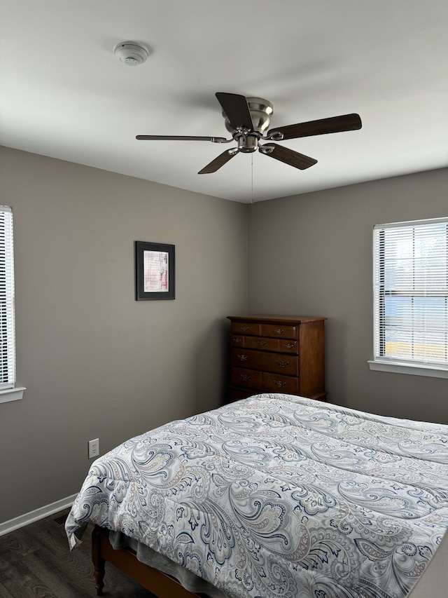 bedroom featuring ceiling fan, baseboards, and wood finished floors