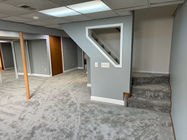 finished below grade area with stairway, light colored carpet, visible vents, and baseboards