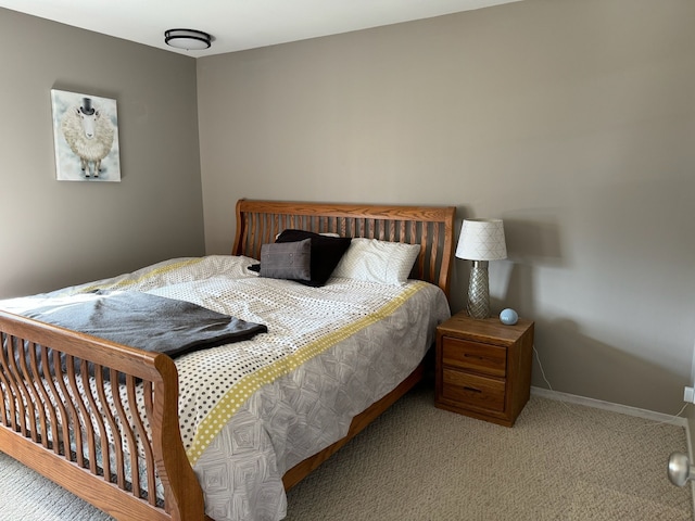 bedroom with baseboards and carpet