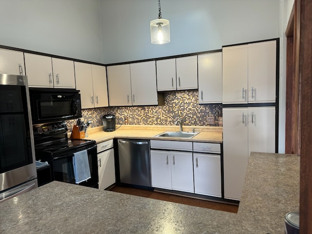 kitchen featuring white cabinetry, black appliances, tasteful backsplash, and a sink