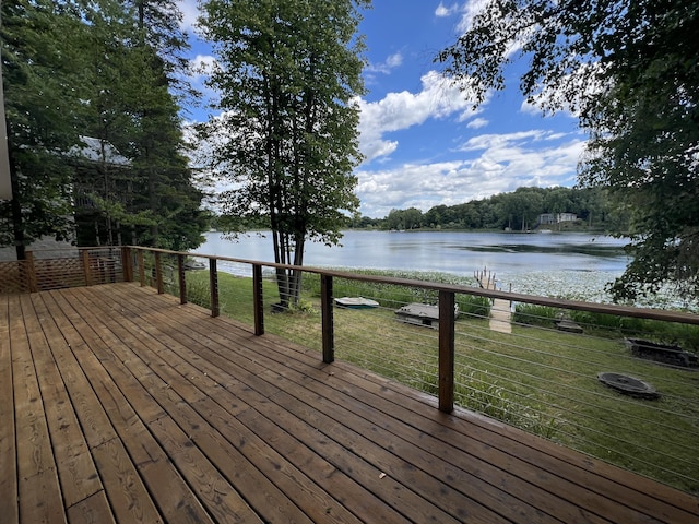 wooden deck with a lawn and a water view