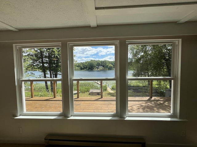 interior details featuring a baseboard heating unit and a water view