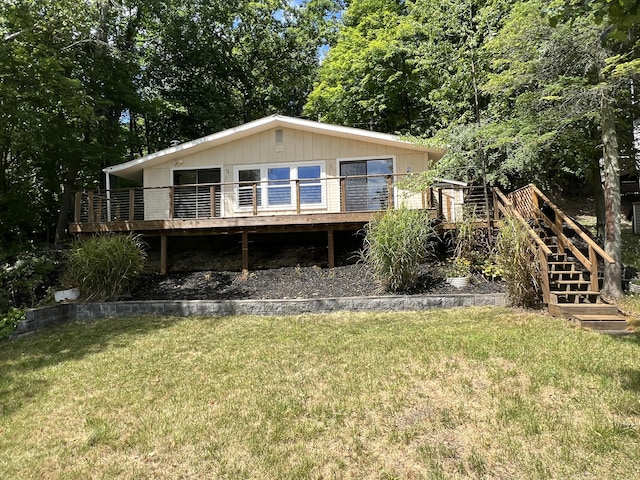 rear view of property with stairway, a lawn, and a wooden deck