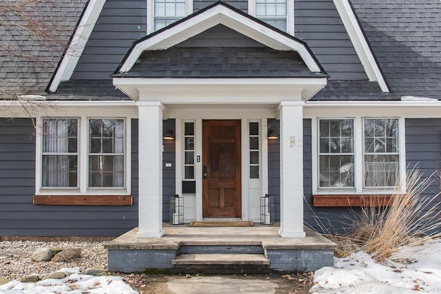 doorway to property with a shingled roof