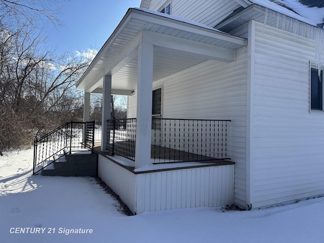 view of snowy exterior featuring covered porch