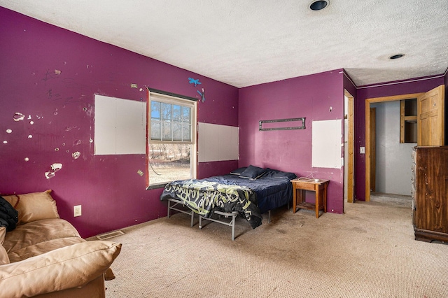 bedroom featuring visible vents, a textured ceiling, and carpet