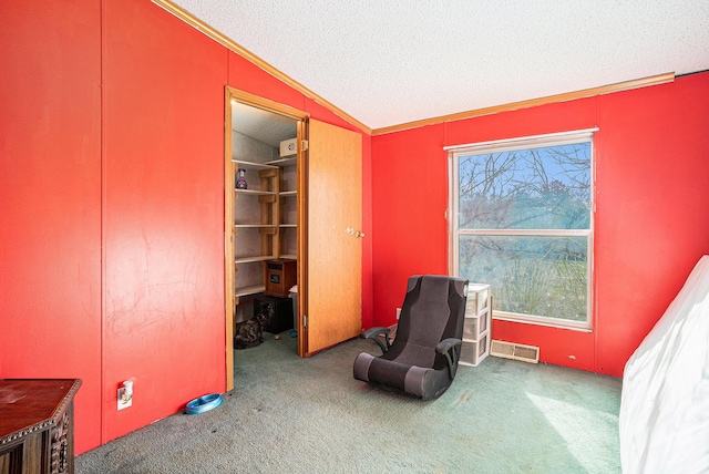 interior space with lofted ceiling, ornamental molding, visible vents, and a textured ceiling