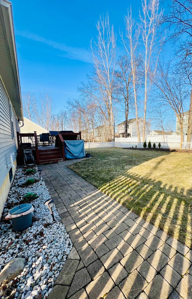 view of yard featuring a deck, a patio, and fence