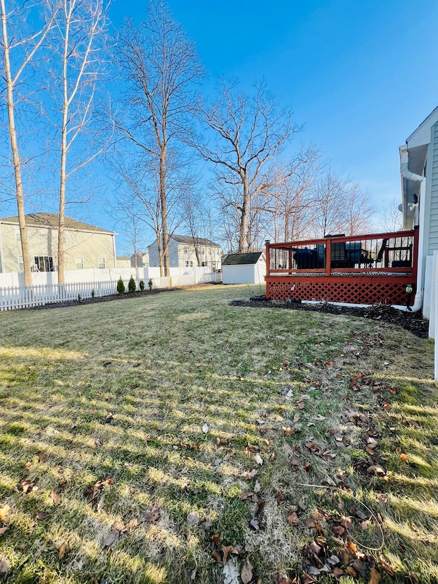 view of yard with an outdoor structure, fence, a shed, and a wooden deck