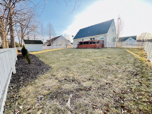 view of yard with an outbuilding, a wooden deck, and a fenced backyard