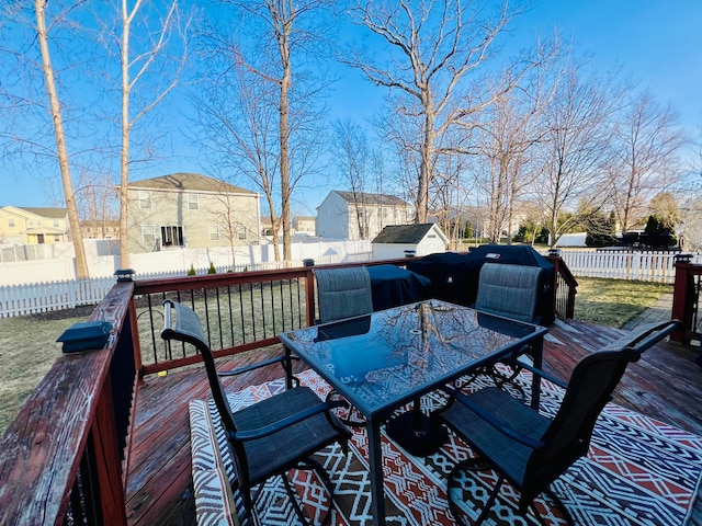 deck featuring outdoor dining area, a residential view, and a fenced backyard