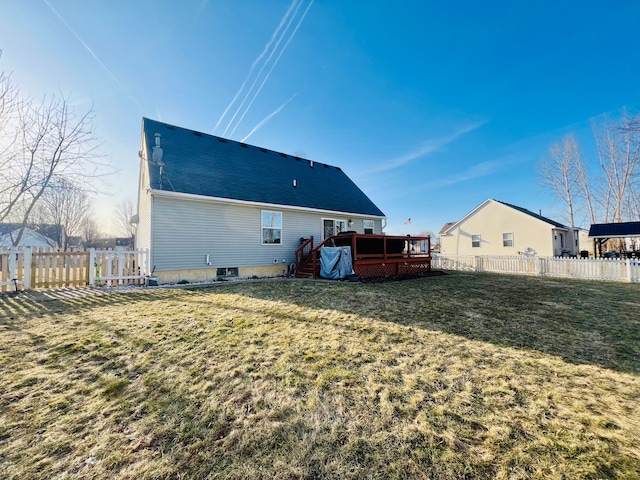 rear view of property featuring a fenced backyard, a lawn, and a deck