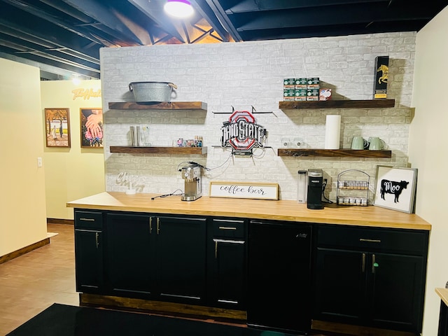 bar with baseboards, backsplash, refrigerator, and wood finished floors