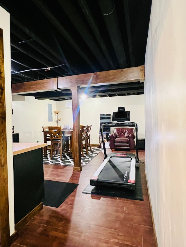 workout area featuring electric panel, wood finished floors, and baseboards