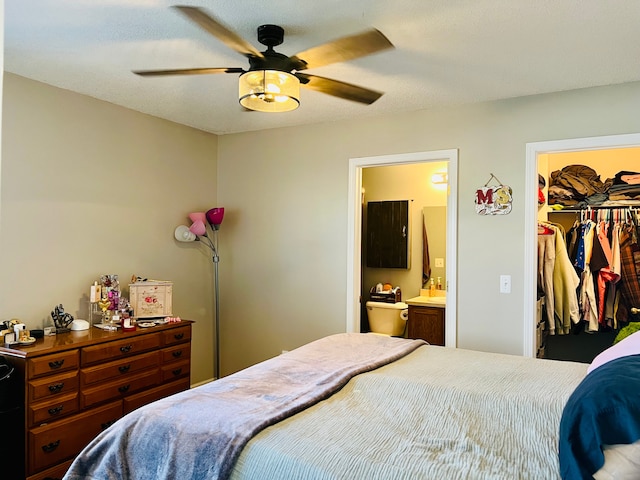 bedroom with a closet, ensuite bath, a walk in closet, and ceiling fan