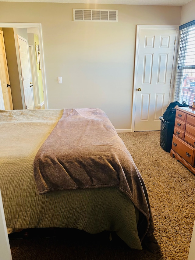 bedroom featuring visible vents, baseboards, and carpet