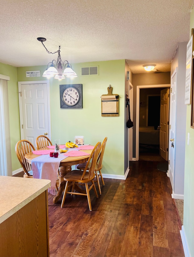 dining area featuring a notable chandelier, dark wood-style floors, visible vents, and baseboards