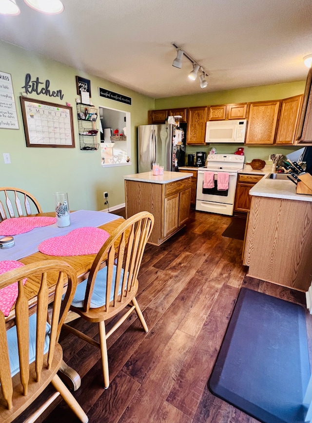 kitchen featuring a center island, white appliances, light countertops, and dark wood-type flooring