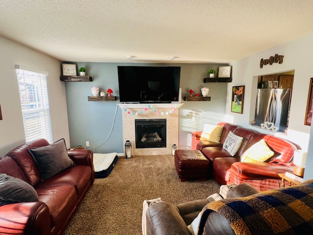 living room with carpet flooring, a tile fireplace, and a textured ceiling