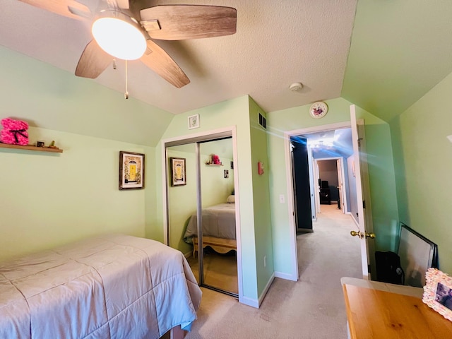 bedroom with a closet, light colored carpet, lofted ceiling, and ceiling fan