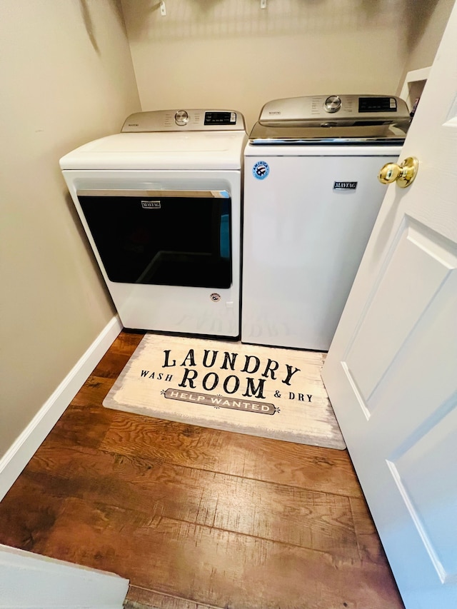 washroom with independent washer and dryer, baseboards, and wood finished floors