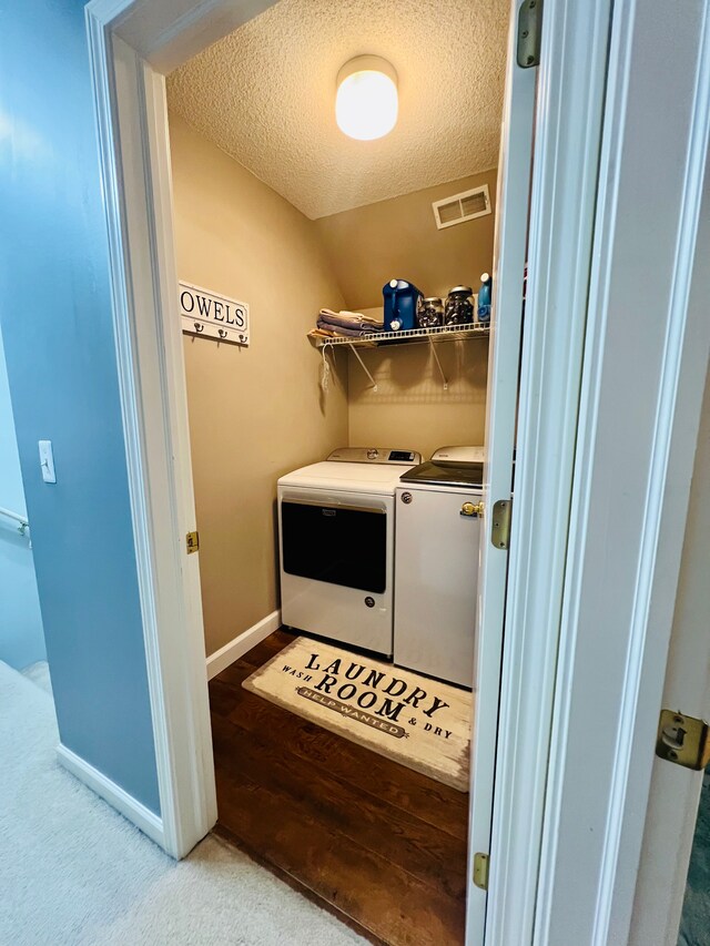 laundry area featuring visible vents, washer and dryer, a textured ceiling, baseboards, and laundry area