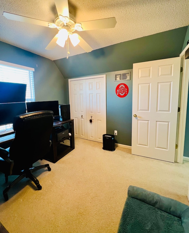 office with vaulted ceiling, a textured ceiling, a ceiling fan, and carpet floors