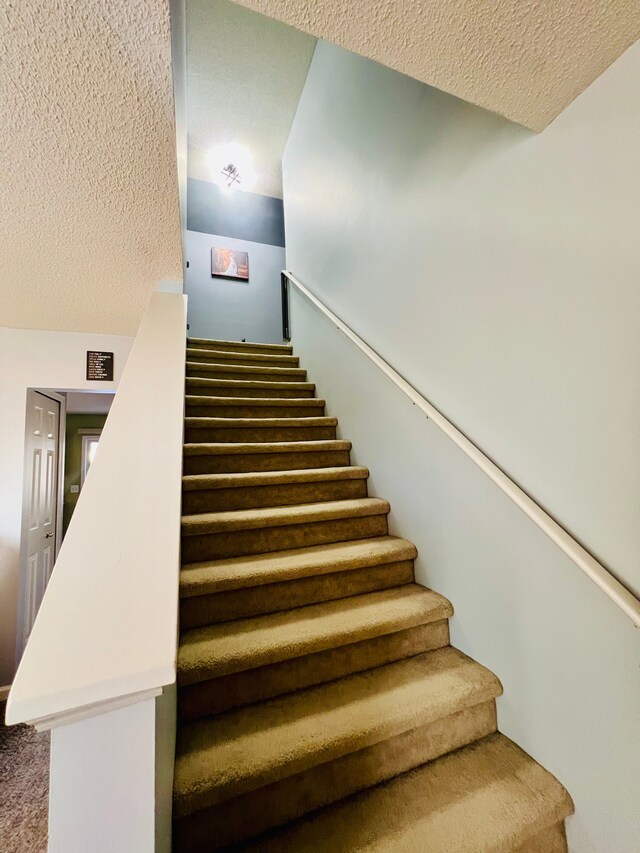 stairway with a textured ceiling