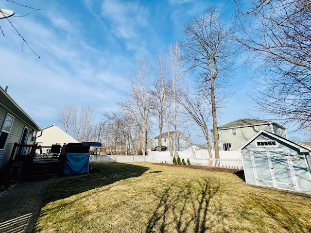 view of yard featuring an outbuilding, a deck, and fence