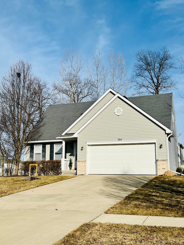 ranch-style house featuring an attached garage, brick siding, driveway, and roof with shingles