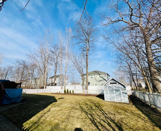 view of yard with a fenced backyard, a shed, and an outdoor structure