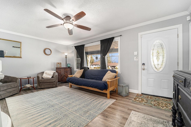 entryway featuring ceiling fan, crown molding, light wood finished floors, and a textured ceiling