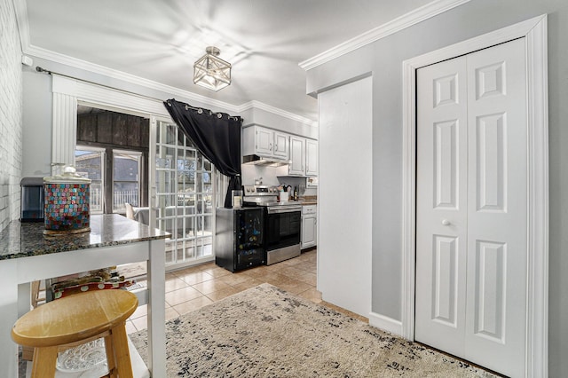 kitchen with electric range, white cabinetry, dark stone counters, light tile patterned flooring, and crown molding