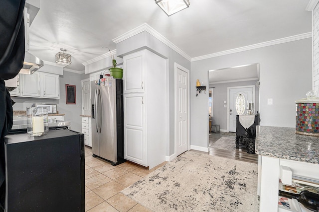 kitchen featuring stainless steel refrigerator with ice dispenser, white cabinetry, light tile patterned flooring, crown molding, and white microwave