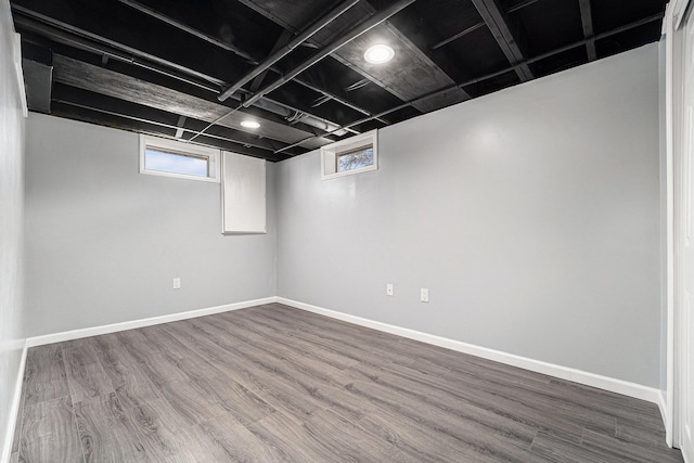 basement with baseboards and wood finished floors