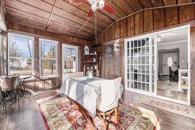 dining space featuring hardwood / wood-style floors, lofted ceiling, wooden walls, and wooden ceiling