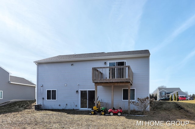 back of property with cooling unit and a balcony