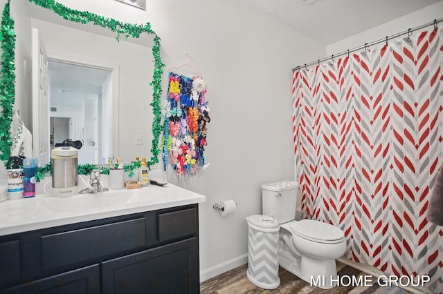 full bathroom with curtained shower, baseboards, toilet, wood finished floors, and vanity