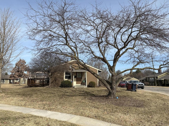 view of front of home with a deck and a front lawn