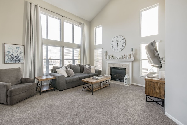 living room featuring high vaulted ceiling, baseboards, carpet floors, and a tile fireplace