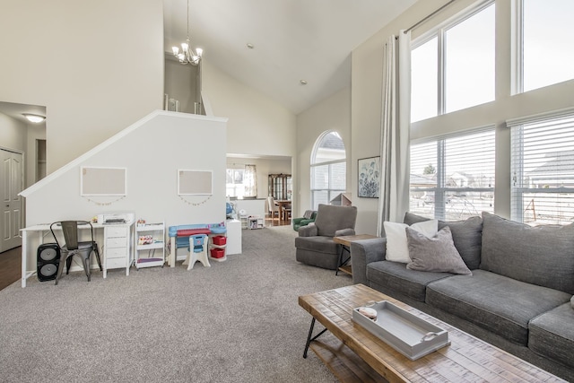 living room with a notable chandelier, high vaulted ceiling, and carpet floors