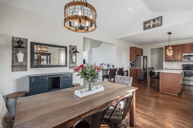 dining space with lofted ceiling, an inviting chandelier, and dark wood-style floors