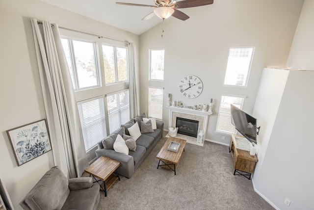 living room featuring a fireplace with flush hearth, high vaulted ceiling, carpet, baseboards, and ceiling fan