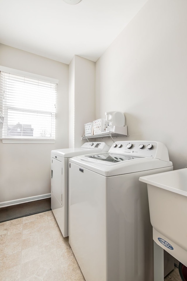 washroom featuring washer and dryer, laundry area, light tile patterned floors, and a sink