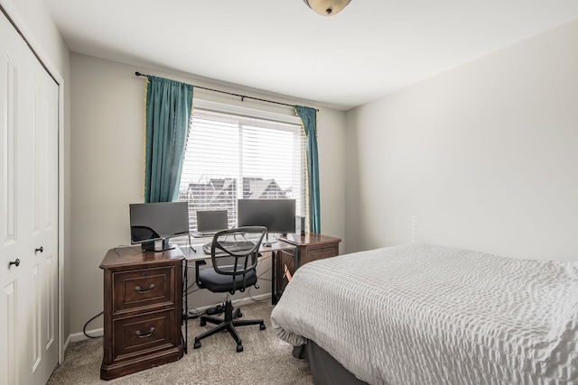 bedroom featuring a closet, light colored carpet, and baseboards