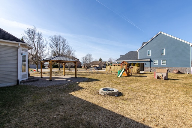 view of yard with a gazebo, a fire pit, and a playground