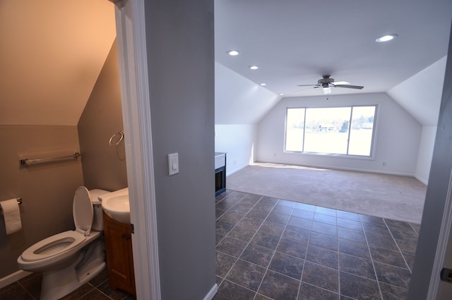 bathroom featuring a ceiling fan, lofted ceiling, toilet, and vanity